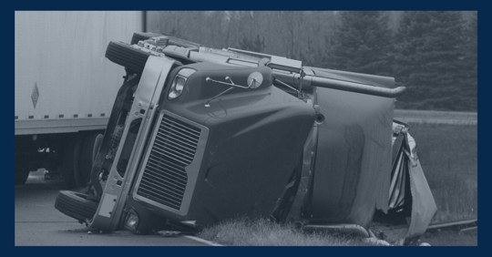 Truck accident with the truck's cab folding into its trailer.